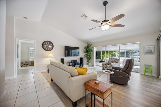 tiled living room featuring ceiling fan and vaulted ceiling