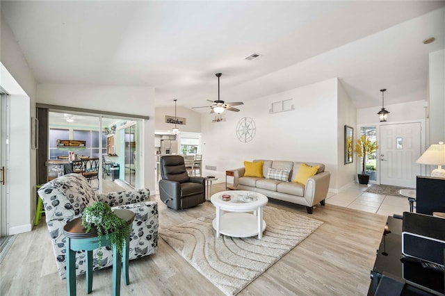 living room with ceiling fan, lofted ceiling, and light wood-type flooring