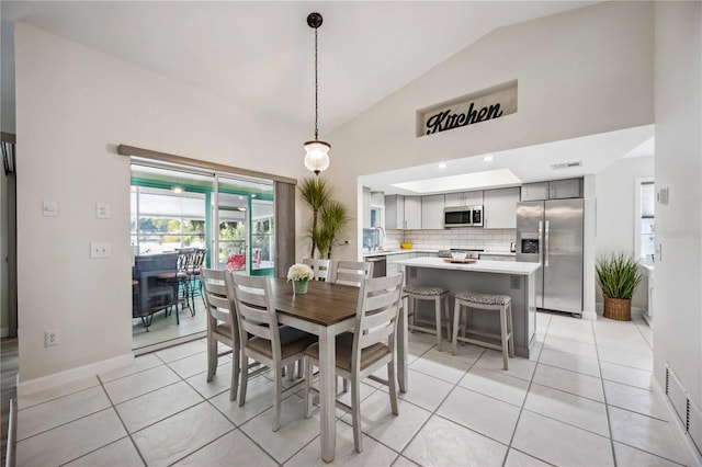 tiled dining room with sink and vaulted ceiling