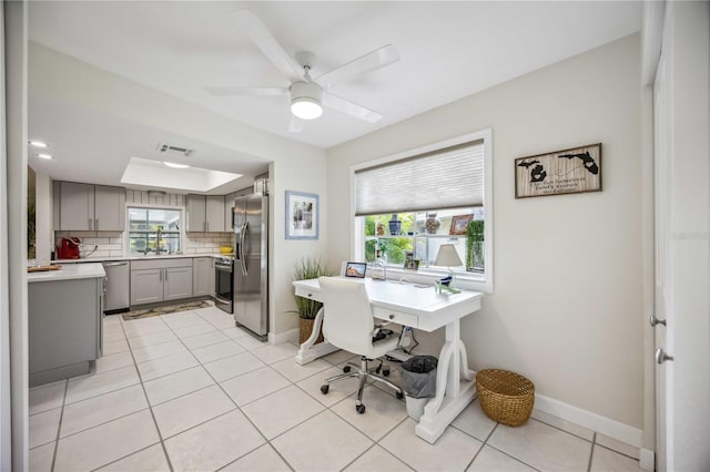 office space featuring sink, ceiling fan, and light tile patterned floors