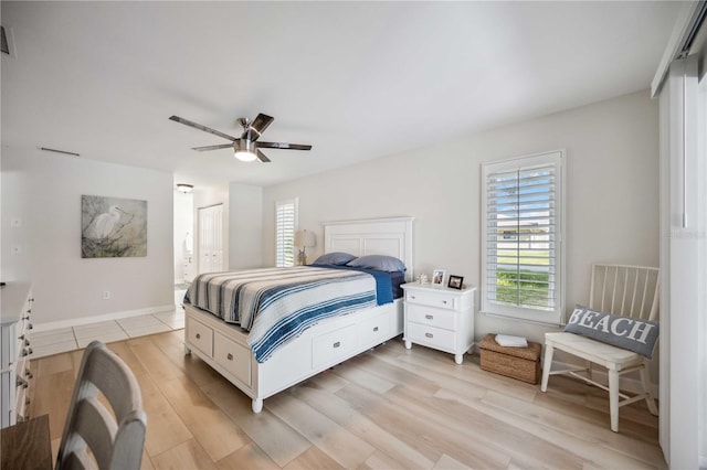 bedroom with a closet, light hardwood / wood-style floors, and ceiling fan