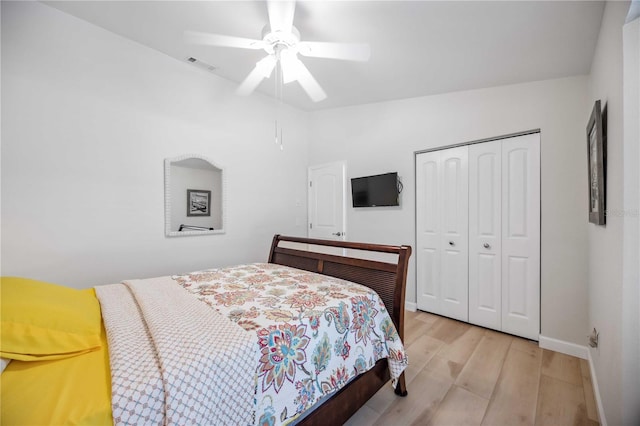 bedroom with light hardwood / wood-style flooring, a closet, and ceiling fan