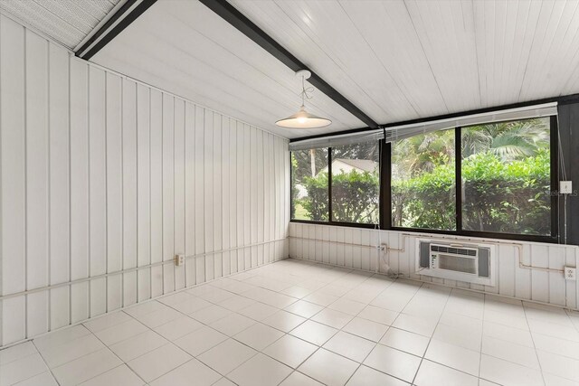 unfurnished sunroom with beam ceiling and a wall unit AC