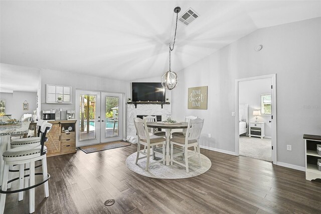 dining space featuring dark hardwood / wood-style flooring, lofted ceiling, a wealth of natural light, and french doors