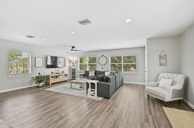 living room featuring ceiling fan, plenty of natural light, and dark hardwood / wood-style floors