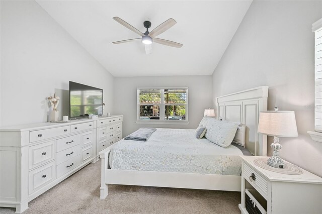 bedroom with ceiling fan, light colored carpet, and vaulted ceiling