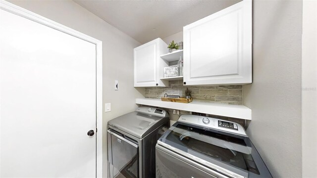 laundry area featuring washing machine and dryer and cabinets