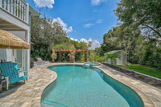 view of swimming pool with a storage unit, a pergola, an in ground hot tub, and a patio