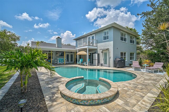 view of pool with an in ground hot tub, area for grilling, and a patio area