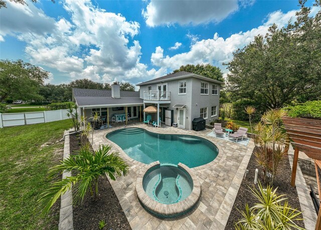 view of pool with an in ground hot tub, a yard, a patio, and area for grilling