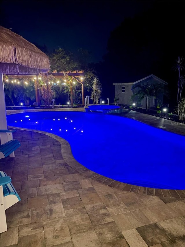 pool at twilight featuring a patio