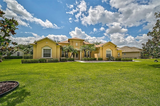 mediterranean / spanish-style home featuring a front yard