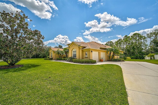 mediterranean / spanish home featuring a front lawn and a garage