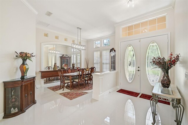 entrance foyer with crown molding, french doors, and a healthy amount of sunlight