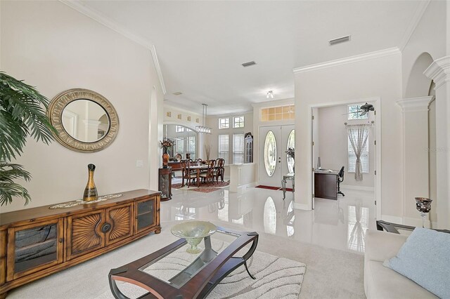 foyer entrance featuring french doors, a chandelier, and ornamental molding