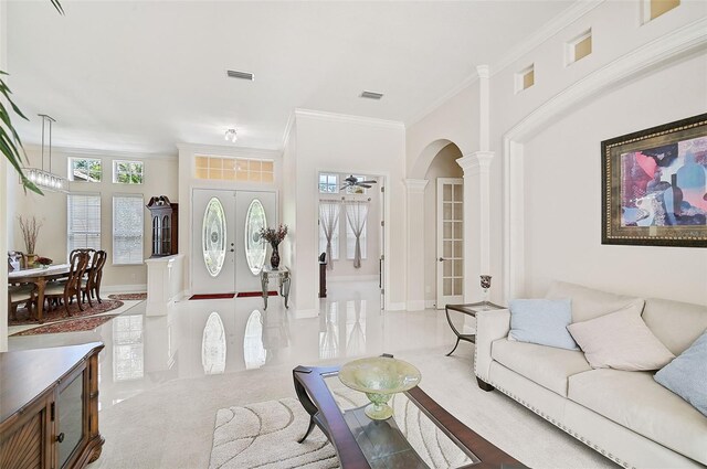 living room featuring ceiling fan, decorative columns, crown molding, and french doors