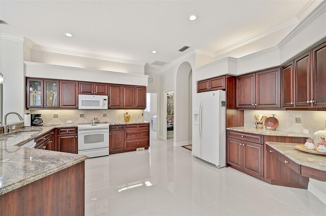 kitchen featuring backsplash, light stone countertops, white appliances, and sink