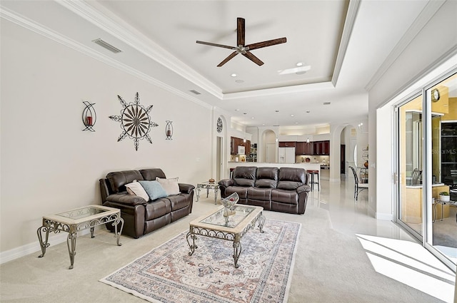 carpeted living room featuring a tray ceiling and ceiling fan