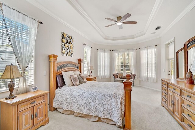 bedroom featuring ceiling fan, a raised ceiling, light carpet, and crown molding