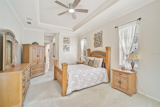 bedroom with a tray ceiling, multiple windows, ceiling fan, and light colored carpet