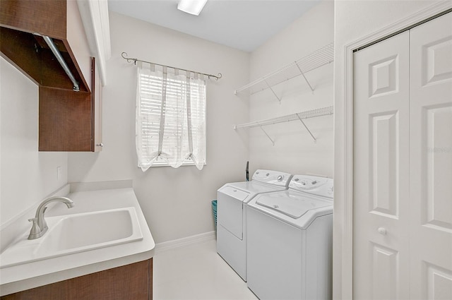 washroom featuring light tile patterned flooring, cabinets, separate washer and dryer, and sink