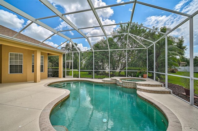 view of swimming pool featuring an in ground hot tub, a patio area, and a lanai