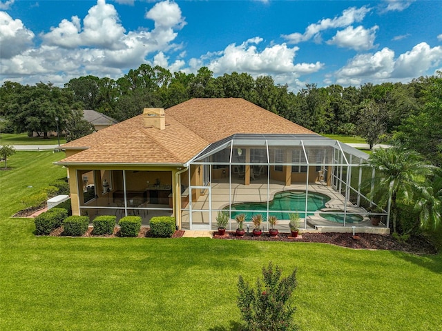 rear view of property with a lawn, a lanai, and a patio