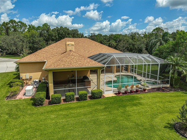 rear view of property with a lawn, a patio area, and a lanai