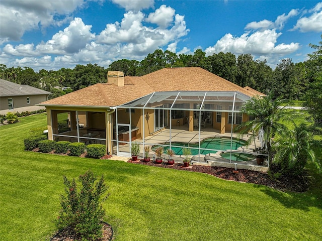 back of property with a lawn, glass enclosure, a pool with hot tub, and a patio