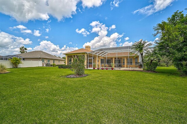 rear view of property featuring a yard and glass enclosure