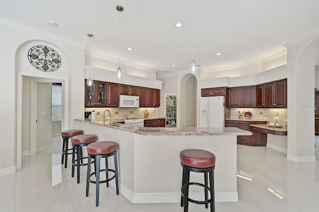 14526 17th Ave E, Bradenton, FL 34212 - kitchen with white appliances, arched walkways, a breakfast bar, ornamental molding, and recessed lighting