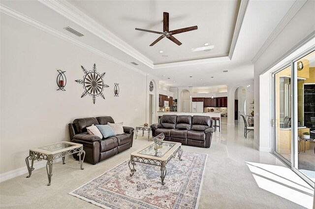 14526 17th Ave E, Bradenton, FL 34212 - living room featuring arched walkways, light colored carpet, a tray ceiling, ceiling fan, and recessed lighting