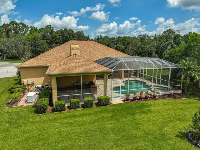 14526 17th Ave E, Bradenton, FL 34212 - back of house featuring roof with shingles, an outdoor pool, a lawn, and a patio
