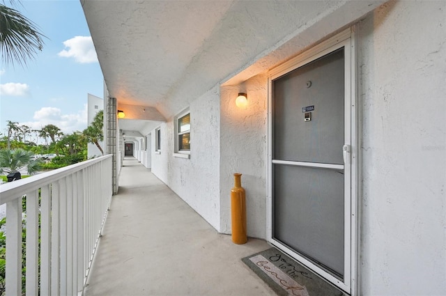 view of exterior entry with a balcony