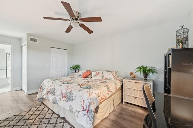 bedroom featuring ensuite bathroom, a closet, ceiling fan, and wood-type flooring