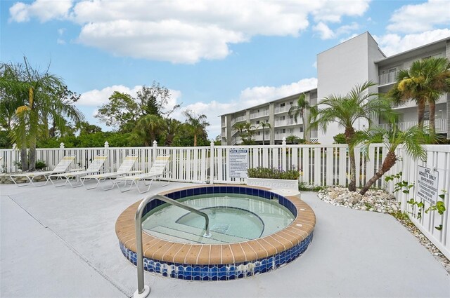 view of swimming pool featuring a hot tub