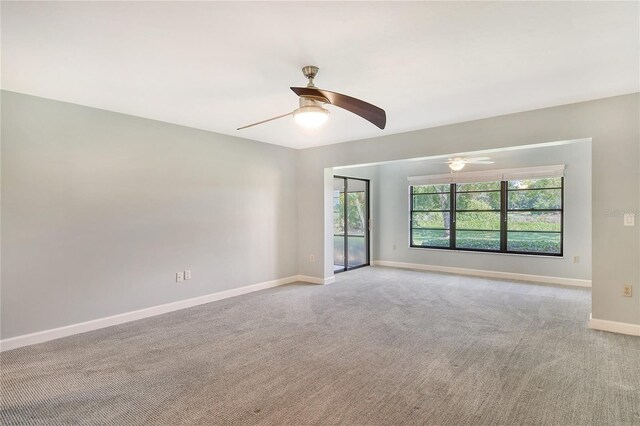 carpeted spare room with ceiling fan