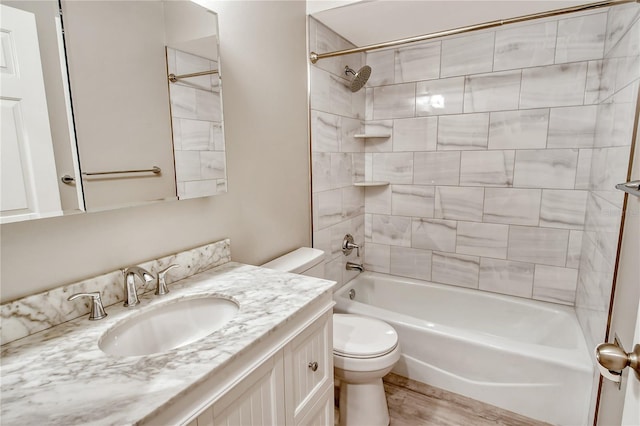 full bathroom with toilet, tiled shower / bath, and vanity