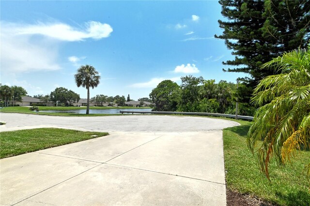 surrounding community featuring volleyball court, a lawn, and a water view