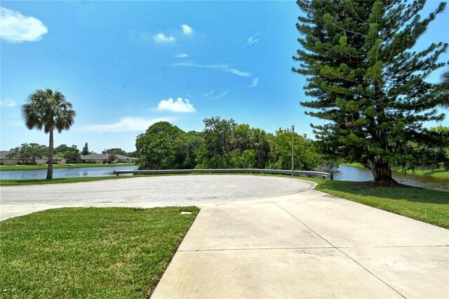 view of community with a yard, a water view, and volleyball court