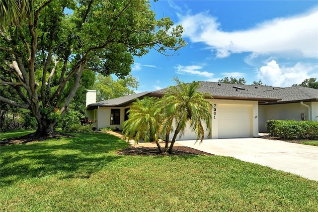 view of front of home featuring concrete driveway, stucco siding, a chimney, an attached garage, and a front yard