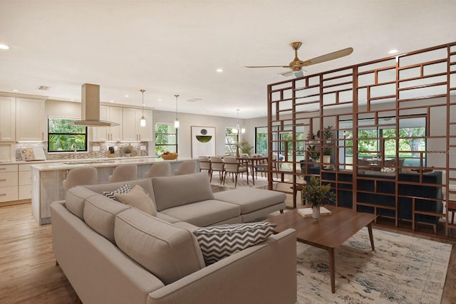 living room featuring ceiling fan and light hardwood / wood-style flooring