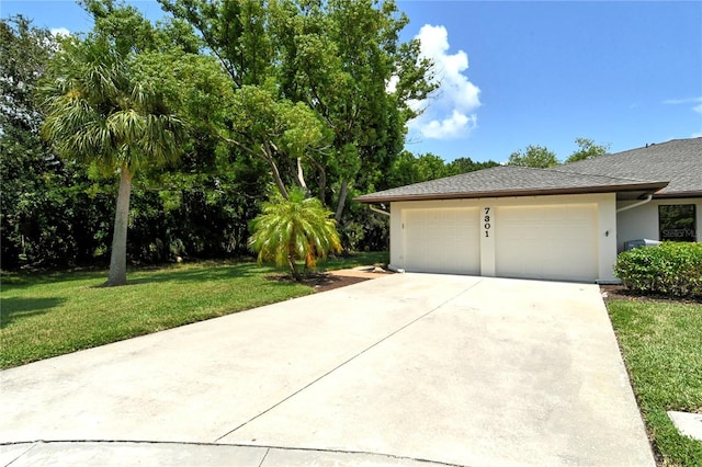 view of side of property with an attached garage, driveway, a lawn, roof with shingles, and stucco siding