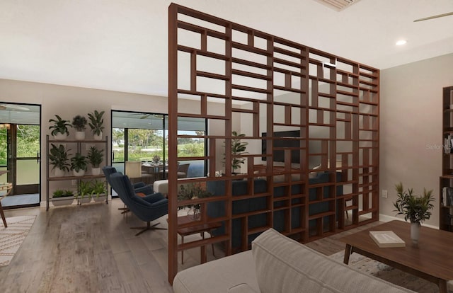 sitting room with baseboards, wood finished floors, and recessed lighting