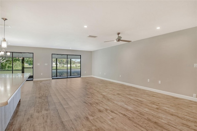 unfurnished living room featuring ceiling fan and light hardwood / wood-style flooring