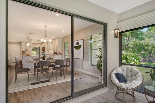 doorway to outside featuring an inviting chandelier and light hardwood / wood-style flooring