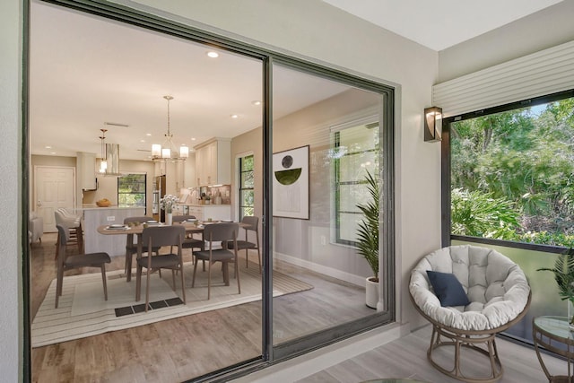 interior space featuring an inviting chandelier, light wood-style flooring, baseboards, and recessed lighting