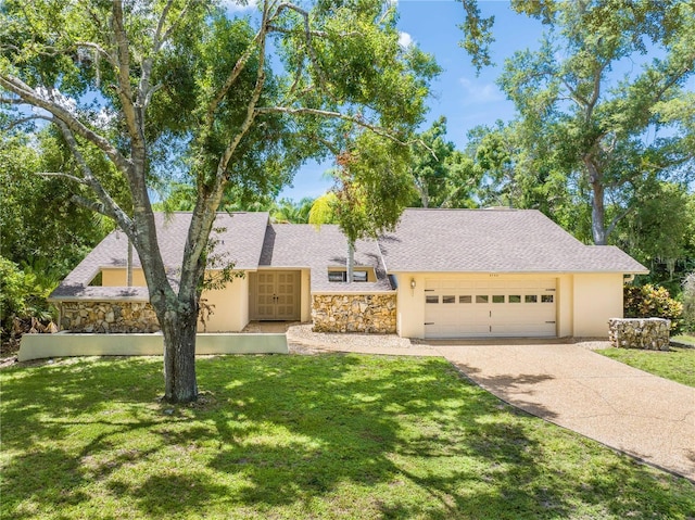 ranch-style house featuring a garage and a front lawn