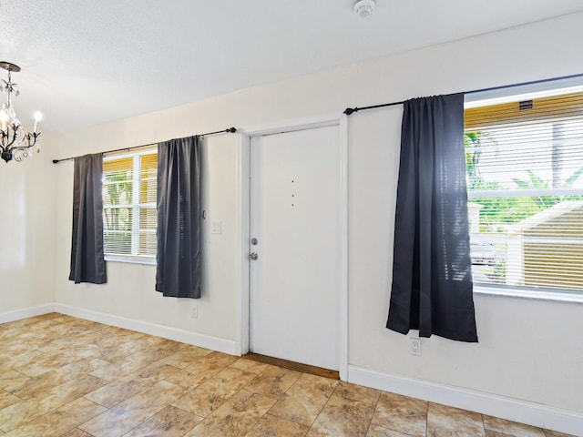 entryway with light tile patterned floors and a chandelier