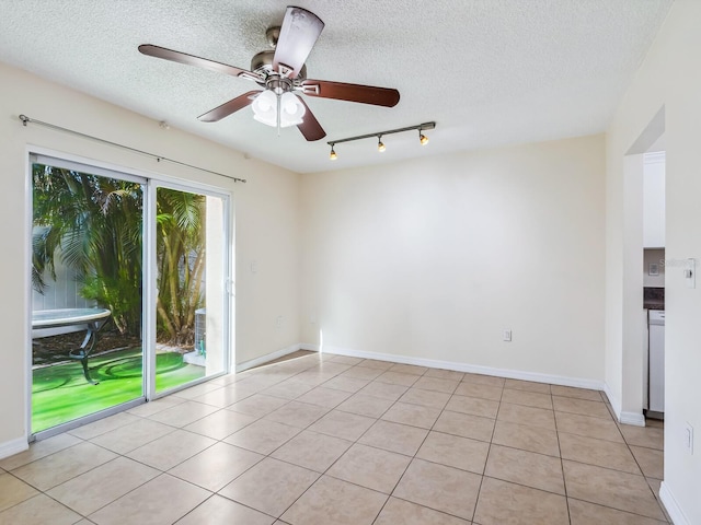 unfurnished room featuring a textured ceiling, ceiling fan, track lighting, and light tile patterned floors